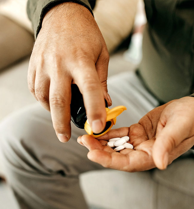 Stock image of a male patient about to take pills