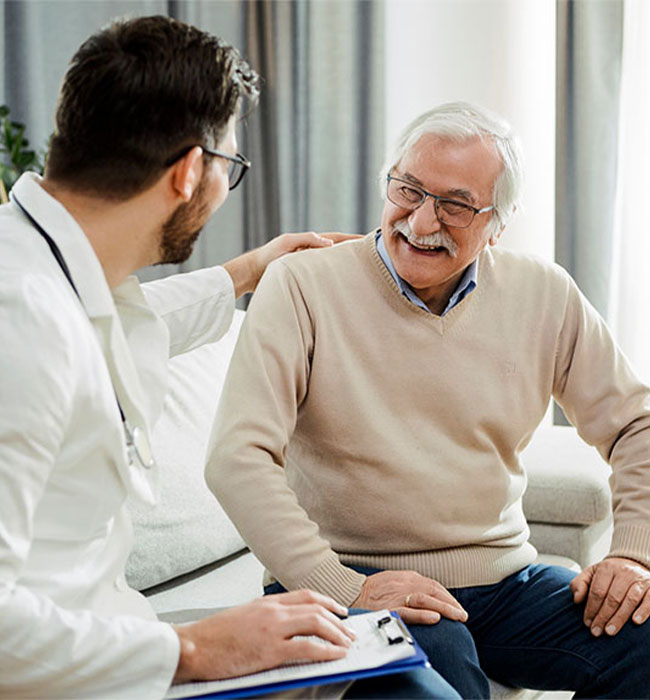 Stock image of a male doctor holding his hand on an elder male patient giving hope