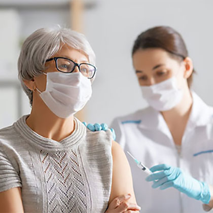 Stock image of a aged woman patient being injected by lady doctor